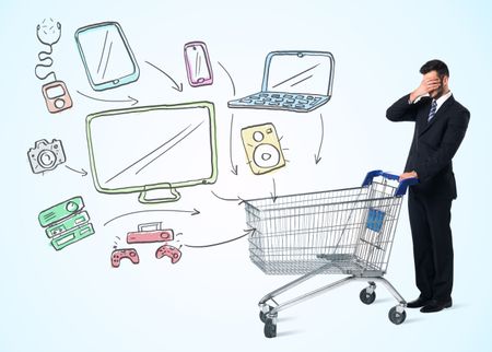 Businessman pushing a shopping cart drawn media devices coming out of it 