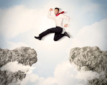 happy-business-man-jumping-cliff-concept-235881499 Happy business man jumping over a cliff concept