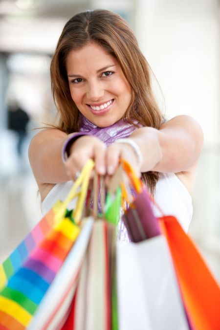 Shopping woman holding some bags in front of her face