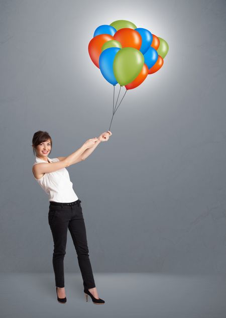 Pretty young woman holding colorful balloons