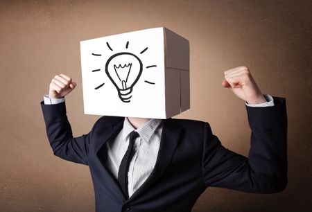 Businessman standing and gesturing with a cardboard box on his head with light bulb