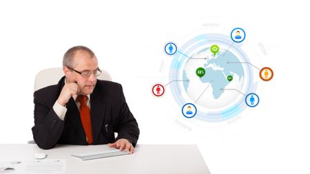 businessman sitting at desk and typing on keyboard with globe and social icons, isolated on white