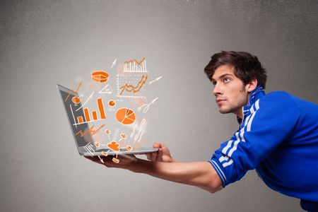 Handsome young man holding laptop with graphs and statistics