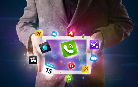 Young businessman holding a tablet with modern colorful apps and icons