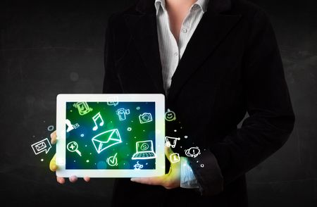 Person holding a white tablet with media icons and symbols