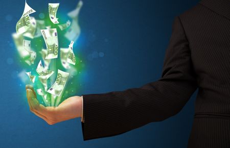 Businessman holding glowing paper moneys in his hand