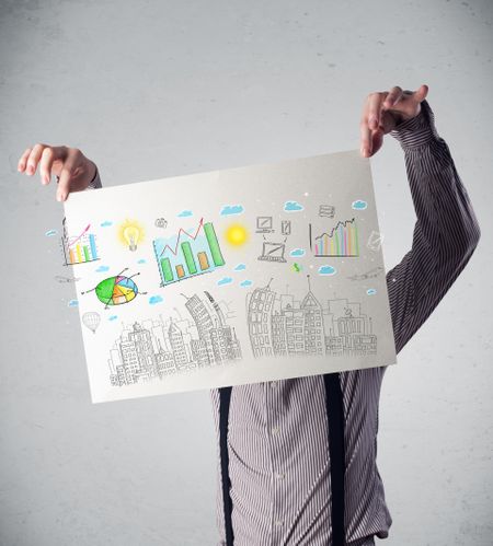 Businessman holding a paper in front of his head with charts and cityscape drawing