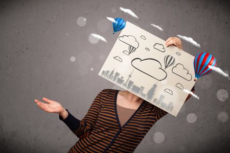 Woman holding a cardboard in front of her head with cityscape and ballons drawing