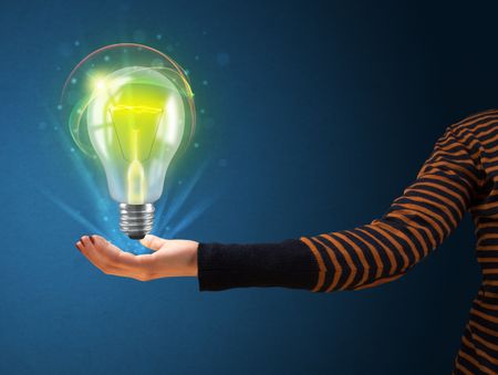 Woman holding a glowing lightbulb in her hand