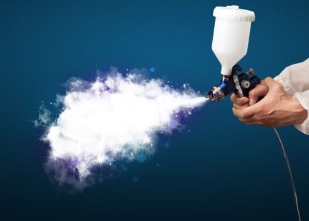Painter with airbrush gun and white magical smoke concept