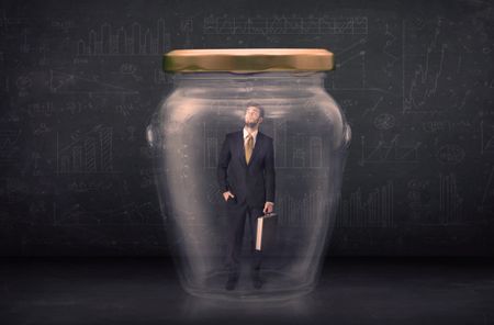 Business man closed into a glass jar concept on background