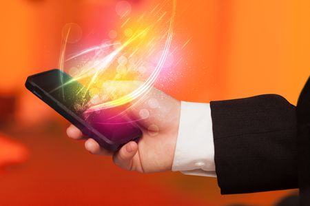 Hand holding smart phone with abstract glowing lines concept