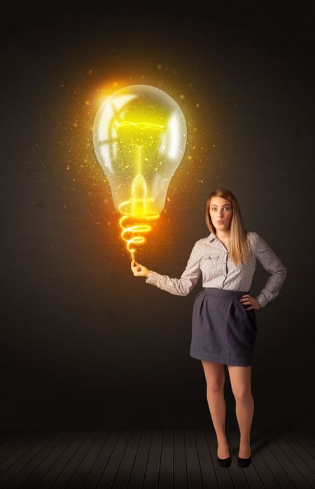 Businesswoman holding a shining, idea bulb