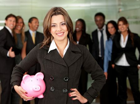 business woman holding a piggy bank at her office - business concepts