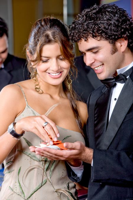 elegant couple at the casino smiling and betting on the roulette