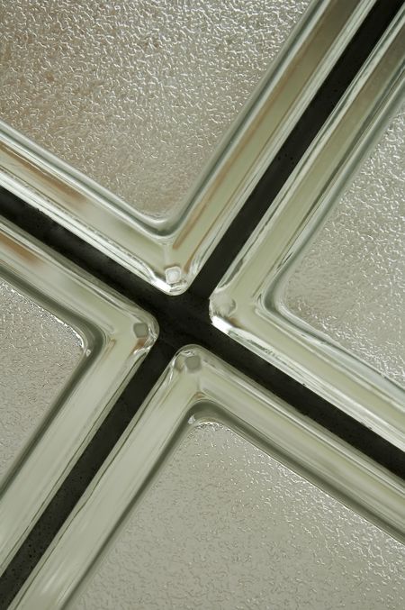 Corners of four opaque bathroom windows with silver frames
