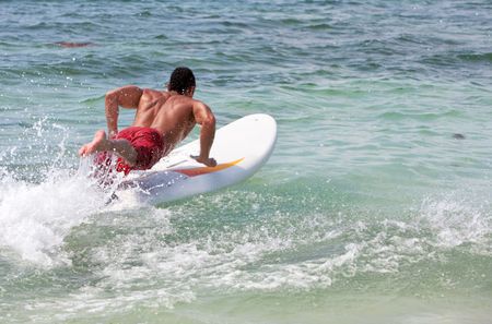 man surfing on his table in the water - watersports
