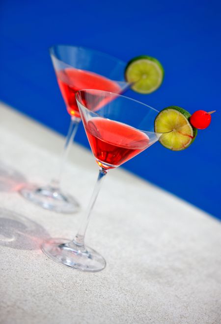 cocktails in martini glasses by a swimming pool