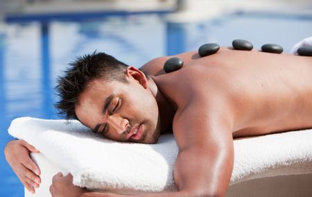 Beauty and Spa - man with zen stones on her back