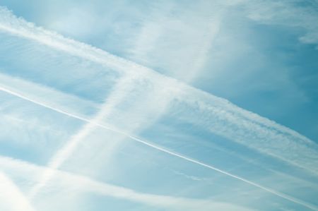 Contrails of jet aircraft across midday sky