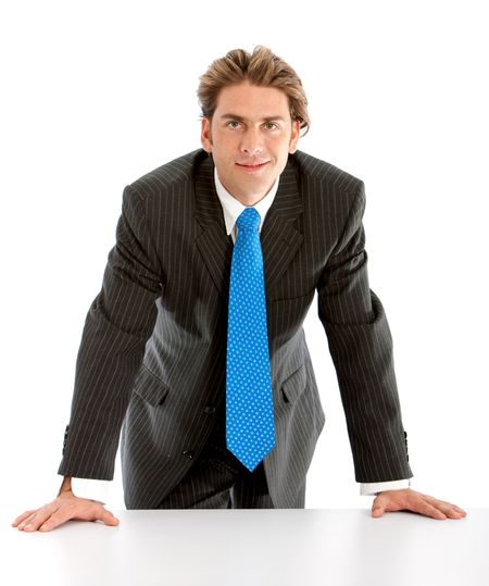 Confident businessman leaning on a table - isolaten on white