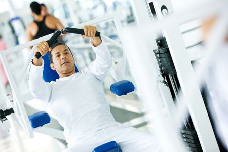 man at the gym doing exercises on a machine