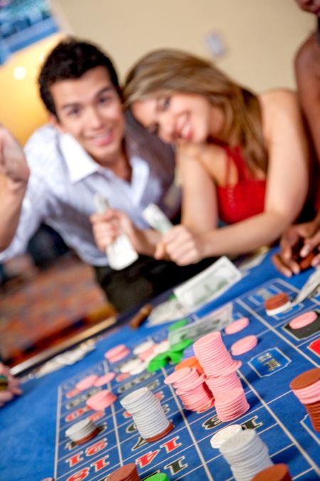 couple at the casino smiling  - focus on a roulette