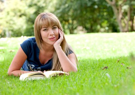 girl reading a book on the floor - outdoors