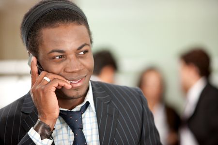 black businessman portrait in an office smiling and talking on the phone