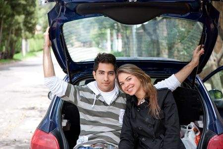 Attractive young couple sitting in the back of a car