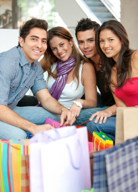 group of friends shopping in a mall with some bags