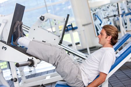 Man exercising his legs with the machines at the gym