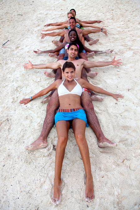 Happy group of friends smiling at the beach