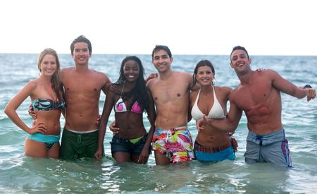 Happy group of friends smiling in the sea water