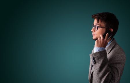 Young man standing and making phone call with copy space
