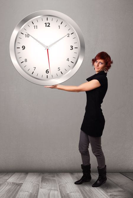 Attractive young lady holding a huge clock