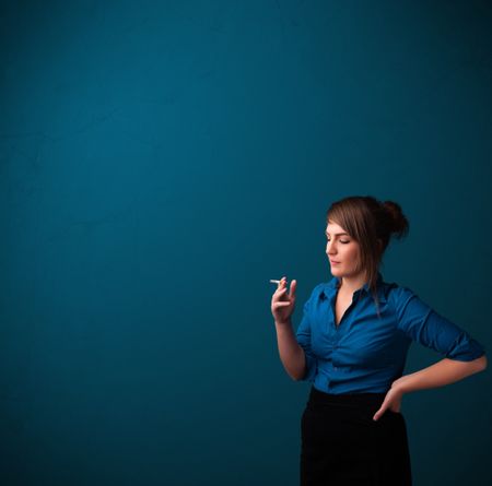 Beautiful young woman smoking cigarette with copy space