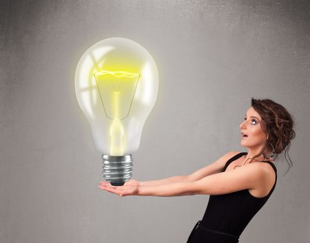 Beautiful young lady holding realistic 3d light bulb