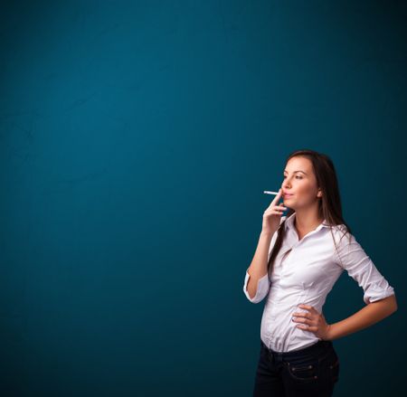 Beautiful young woman smoking cigarette with copy space