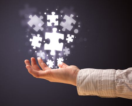 Woman holding shining puzzle pieces in her hand