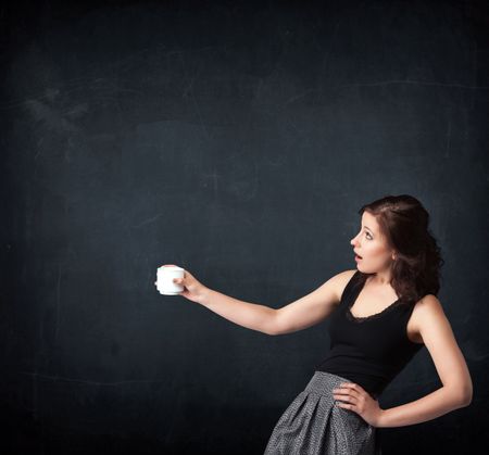 Businesswoman standing and holding a white cup on a black background 