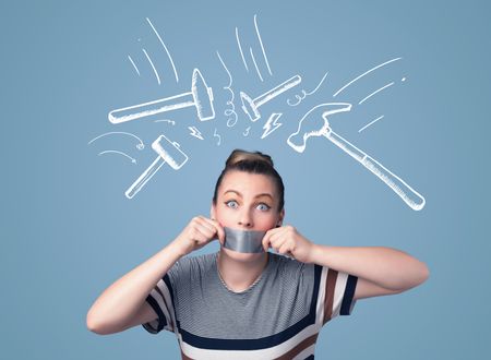 Young woman with taped mouth and white drawn beating hammer marks around her head