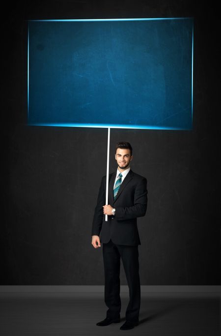 Young businessman holding a big, blue board
