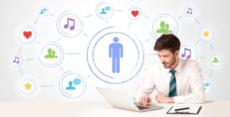 Businessman sitting at white table with social media connection background