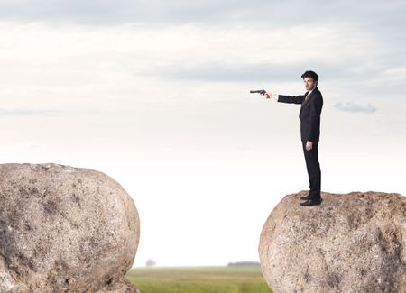 Young businessman standing on edge of rock mountain