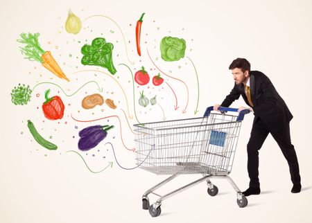 Businessman pushing a shopping cart and healthy vegetables coming out of it