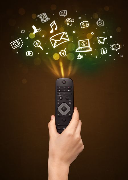 Hand holding a remote control, social media icons coming out of it 