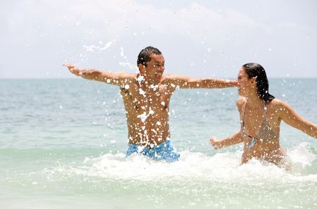 couple enjoying their vacations and splashing water to each other