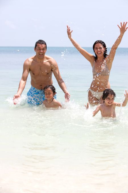 Family enjoying their vacations and splashing water to each other