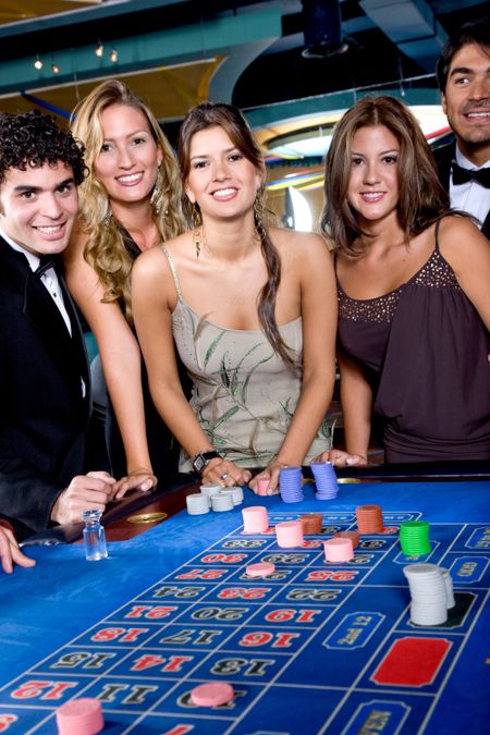 Group of people smiling playing roulette at a casino